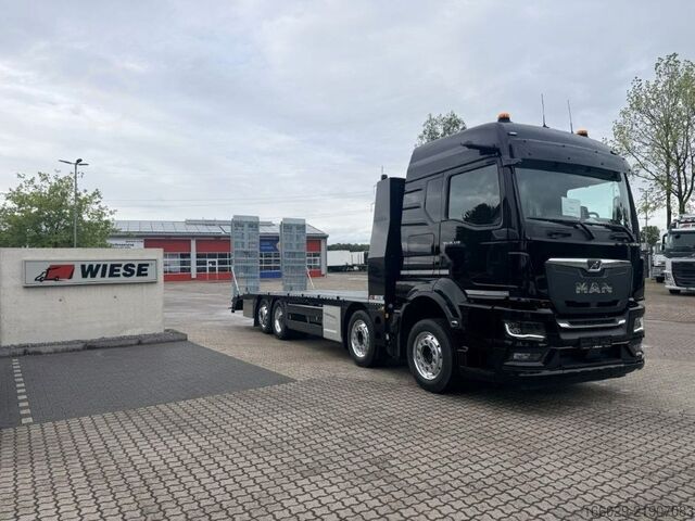 Ciężarówka z płaską platformą MAN Baumaschinen Maschinentransporter mit Rampen
